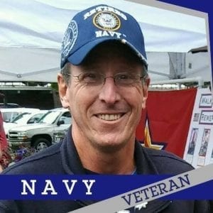 A retired Navy Veteran and colon cancer survivor Daniel "Dry Dock" Shockley smiles while wearing a blue Navy hat