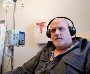 A pastor with stage IV colon cancer named Daniel Nicewonger listens to music while getting chemotherapy.