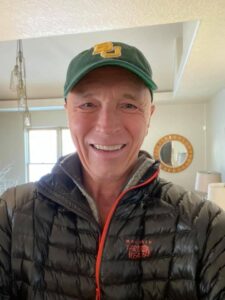 Dr. Jeff Myers wears a hat and puffy jacket looks pale after the cancer treatment. 