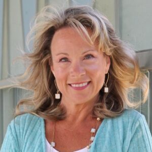 Michelle Bengtson, author, neuropsychologist, cancer survivor, smiles in a turquoise blouse. 