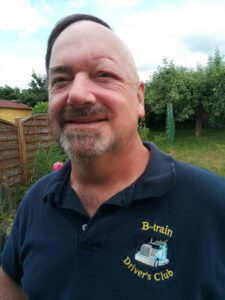 Al Drinkwalter, a melanoma survivor, smiles for a photo. Because of radiation, he is missing an eyebrow and hair on the left side of his face.